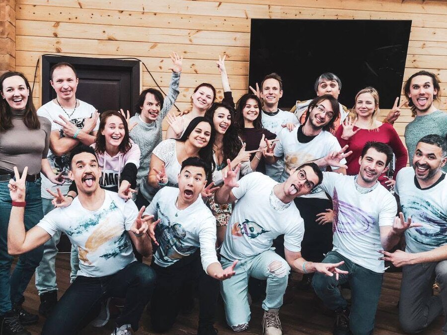 A group of dancers in matching white t-shirts pulling faces for the camera