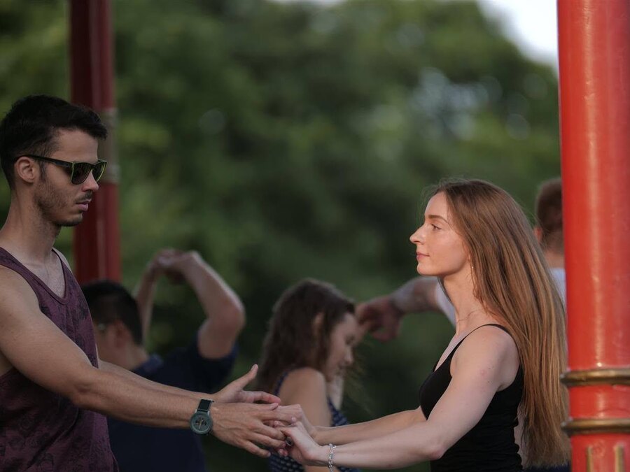 A couple dancing at an outdoor social, other dancers behind them